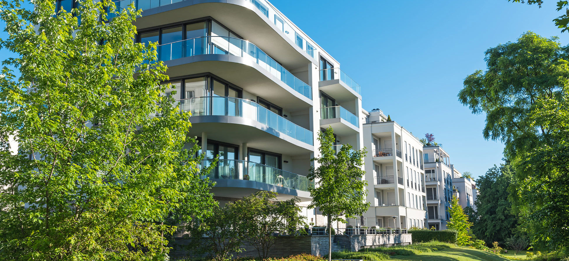 Moderne Wohnanlage mit Balkonen zwischen Bäumen